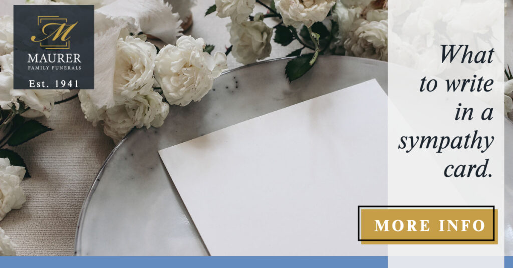 Sympathy card resting on white roses