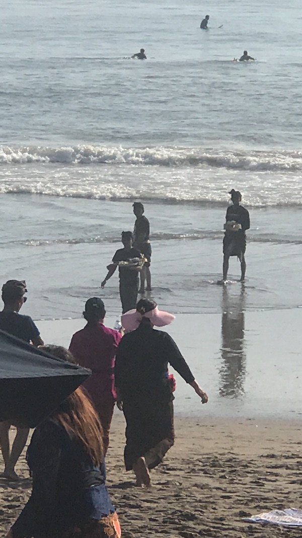 Family and friends gathered at the water's edge on the beach